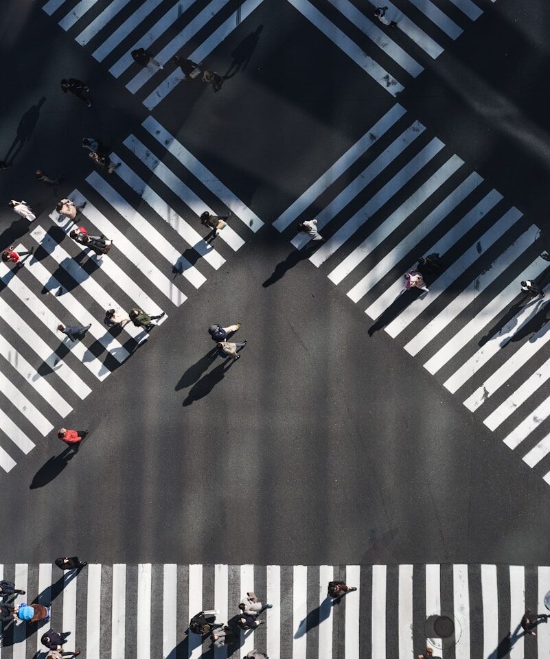 aerial photography of people walking in the intersection street during daytime